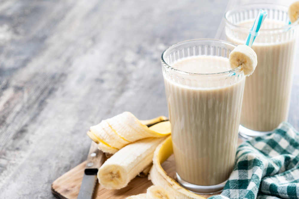 Image of a classic banana smoothie in a tall glass with a sprinkle of cinnamon on top.