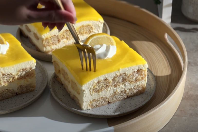 A luscious tiramisu dessert with a bright citrus twist. In the foreground, layers of delicate ladyfingers soaked in a rich lemon curd, dusted with a fine layer of cocoa powder. The middle ground showcases a creamy mascarpone filling, infused with the zesty essence of freshly grated lemon zest. Soft, ambient lighting casts a warm glow, highlighting the glossy sheen of the lemon curd and the pillowy texture of the tiramisu. The background fades into a soft, out-of-focus setting, allowing the dessert to take center stage. The overall mood is one of elegance and indulgence, inviting the viewer to savor the bright, citrusy twist on a classic Italian treat. Tiramisu with Lemon Curd